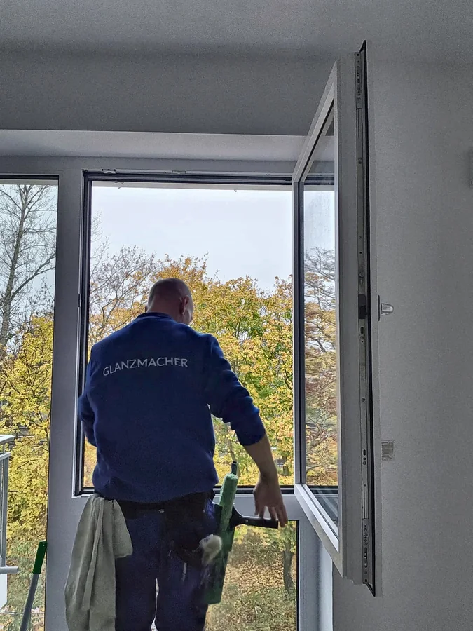 Fenster putzen lassen Berlin: Fensterputzer von GLANZMACHER reinigt ein Fenster mit dem Abzieher